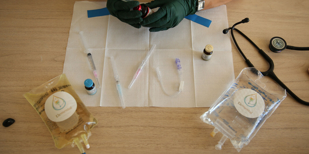 Gloved hands preparing injection supplies on a table beside a stethoscope