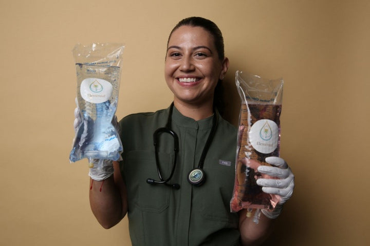 Elemental IV Therapy nurse holding two IV drip bags